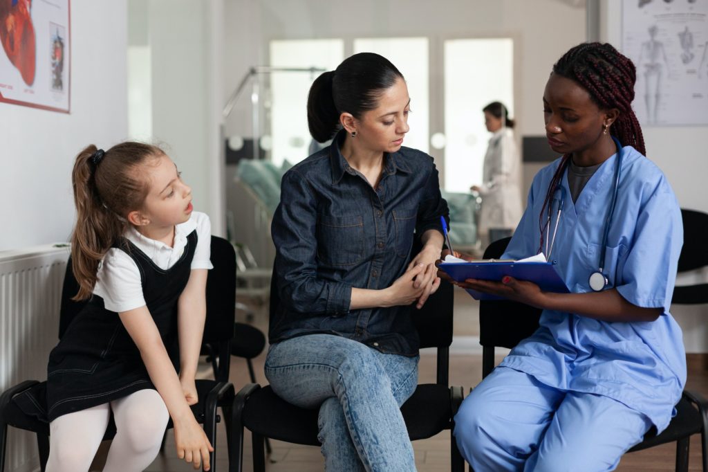 Family discussing medical treatment with african american nurse in hospital